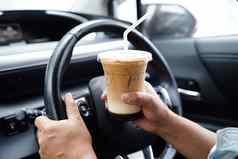 亚洲女人司机持有冰咖啡杯喝车危险的风险事故