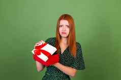 年轻的红色的头发女人绿色背景礼物盒子不开心伤心失望