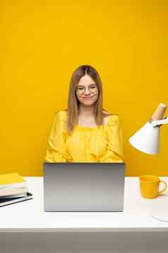肖像漂亮的年轻的女人研究坐着表格灰色移动PC电脑笔记本微笑业务女人工作移动PC孤立的灰色背景