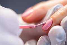 美容师适用于粉红色的混合动力波兰的客户的指甲