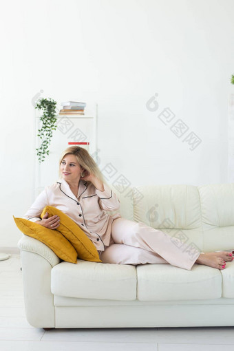 微笑金发女郎女人坐着舒适的教练生活房间睡衣家居服免费的时间假期首页概念