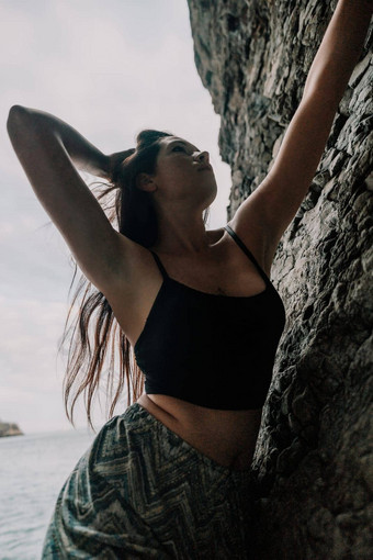 体育女人攀爬岩石年轻的女人苗条的适合身体攀爬火山玄武岩洞穴美丽的海视图运动员女孩火车自然女人<strong>克服</strong>了困难攀爬路线