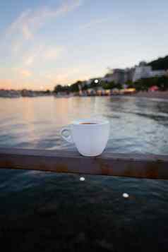 阳台餐厅海白色杯咖啡站码头背景美丽的度假胜地小镇
