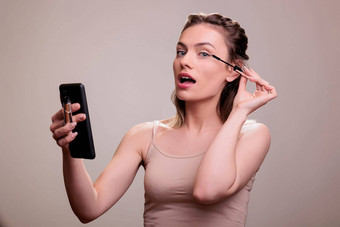 女人应用睫毛膏睫毛智能手机屏幕