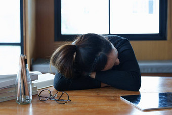 肖像十几岁的亚洲女人睡觉桌子上图书馆由于<strong>乏力</strong>研究