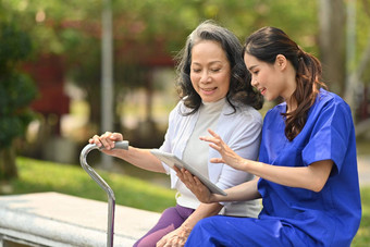 有<strong>爱心</strong>的女医生解释<strong>医疗</strong>结果高级女人坐着板凳上康复中心公园