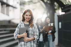 年轻的亚洲女人大学学生朋友在户外大学学生工作大学校园教育学校研究