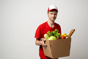 交付男人。红色的统一的持有<strong>纸盒子</strong>食品杂货快免费的交付运输在线购物表达交付