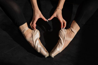 不知名<strong>的</strong>芭蕾舞女演员<strong>坐在地板上</strong>使心形状手尖端鞋子前视图