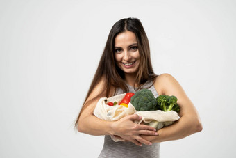 微笑浅黑肤色的女人女孩持有网<strong>购物</strong>袋蔬菜绿色塑料袋浪费塑料<strong>免费</strong>的生态友好的概念可持续发展的生活方式