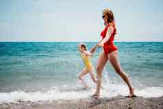 快乐爱的家庭妈妈。女儿有趣的海滩妈妈玩孩子假期假期海洋家庭生活方式爱概念