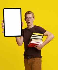 惊讶学生持有书平板电脑空白白色屏幕复制空间黄色的背景展示概念现代教育集成技术学习研究