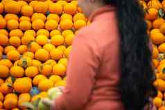 橙子基努柑橘类水果堆路边摊位显示农民传统上出售当地的水果焦点女人购买