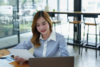 肖像深思熟虑的亚洲女商人金融语句使市场营销计划电脑桌子上