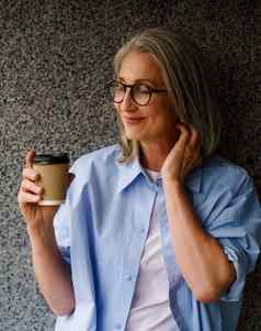 快乐的时尚的高级女人咖啡杯手站墙城市城市设置辐射幸福放松使完美的图像说明无忧无虑的内容生活方式