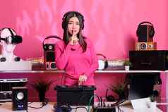 亚洲艺术家把食指嘴唇手势嘘标志执行电子音乐工作室