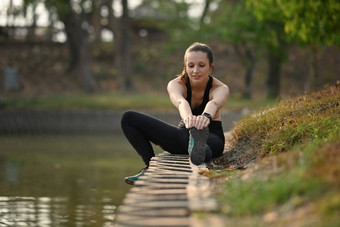 运动女人运动女人伸展运动练习湖健康的生活方式体育运动健身概念