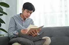 平静千禧亚洲男人。闻沙发上阅读书支出质量时间首页
