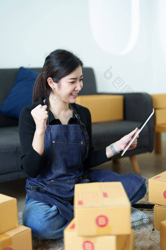 启动小业务企业家自由亚洲女人微笑平板电脑电脑快乐的成功项在线市场营销包装盒子交付锻造的想法概念