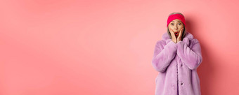 时尚概念时尚的亚洲女人惊讶相机成熟的女紫色的外套头巾惊讶相机检查促销活动粉红色的背景
