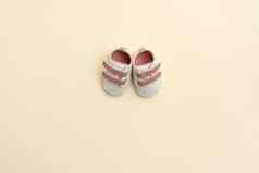 婴儿粉红色的鞋子黄色的纸背景复制空间婴儿衣服概念前视图平