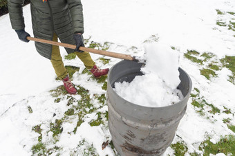 中年女人收集雪<strong>桶</strong>铲自然资源