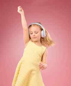 音乐耳机跳舞女孩孩子们工作室粉红色的背景颜色背景幸福快乐孩子们跳舞听广播音频声音能源有趣的歌曲自由
