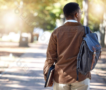 黑色的男人。走背包校园公园自然花园大学大学学校研究发展学生基因人学习书教育袋增长心态