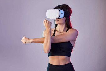 虚拟现实健身女人伸展运动元宇宙工作室孤立的紫色的背景锻炼女运动员温暖的锻炼培训未来主义的耳机的<strong>电子竞技</strong>