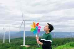 进步年轻的亚洲男孩玩风纸风车玩具风涡轮农场