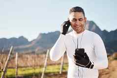 耳机自然快乐男人。电话休息停止农村位置在线音乐移动流媒体健身应用程序智能手机骑自行车的人互联网搜索微笑