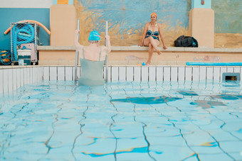 游泳运动员游泳池女人离开水有趣的游泳水生锻炼培训健身锻炼水疗中心上了年纪的朋友放松享受游泳健康室内池