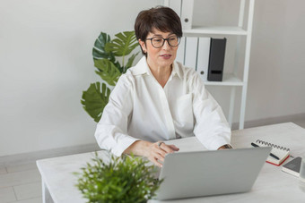 成熟的业务女人会说话的出售报告视频会议女移动PC在线会议视频调用工作办公室视频调用在家中上班