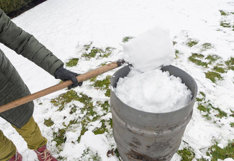 中年女人收集雪<strong>桶</strong>铲自然资源