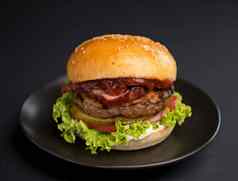 大美味的汉堡牛肉帕蒂生菜培根泡菜黑色的背景