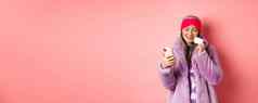 在线购物时尚概念时尚的亚洲祖母使购买互联网智能手机塑料信贷卡粉红色的背景