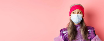 科维德病毒时尚概念惊讶惊讶亚洲祖母时尚的装医疗面具左深刻的印象粉红色的背景