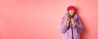 肖像时尚的亚洲高级女人紫色的冬天外套畏缩恶心的皱着眉头转尴尬的显示停止手势拒绝粉红色的背景