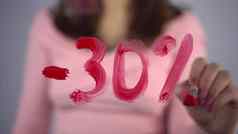 年轻的女人吸引了玻璃折扣-百分比女孩粉红色的毛衣吸引了刷红色的油漆特写镜头