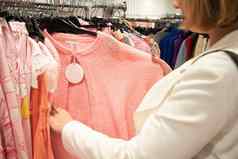 女孩千禧商店选择悬挂器粉红色的上衣时尚衣服