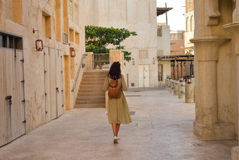 女人背包走街道城市阿联酋航空公司波斯海湾泥房子al-sif德伊勒burdubai旅行观光概念
