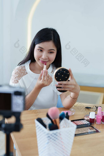 在线交易业务美丽的年轻的女人工作独立首页回顾化妆品产品相机客户增加感兴趣使购买决定