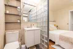 开放紧凑的浴室毗邻的主卧室玻璃砖米色平铺的水槽厕所。。。货架上概念小深思熟虑的现代公寓