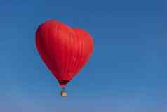 热空气气球形状心蓝色的天空度蜜月概念新婚夫妇