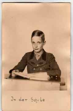 古董照片显示年轻的男孩学生学校桌子上学生穿期夹克用橡木制的肩章标志着夹克摄影文本德国学校翻译英语