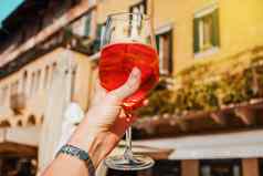 女手玻璃橙色鸡尾酒斯普利茨建筑阳光明媚的一天维罗纳意大利