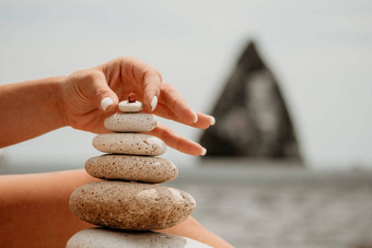 女人图片石头金字塔海滨阳光明媚的一天蓝色的海背景快乐假期卵石海滩平静海旅行目的地概念快乐假期海冥想水疗中心