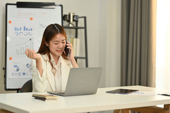 美丽的女金融顾问电话谈话客户<strong>端</strong>移动<strong>PC</strong>明亮的办公室