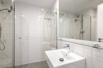 舒适的简洁的浴室白色瓷砖水槽玻璃幕墙淋浴概念便宜的简单的时尚的改造浴室Copyspace