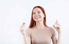 快乐年轻的女人香水持有玻璃瓶孤立的白色背景